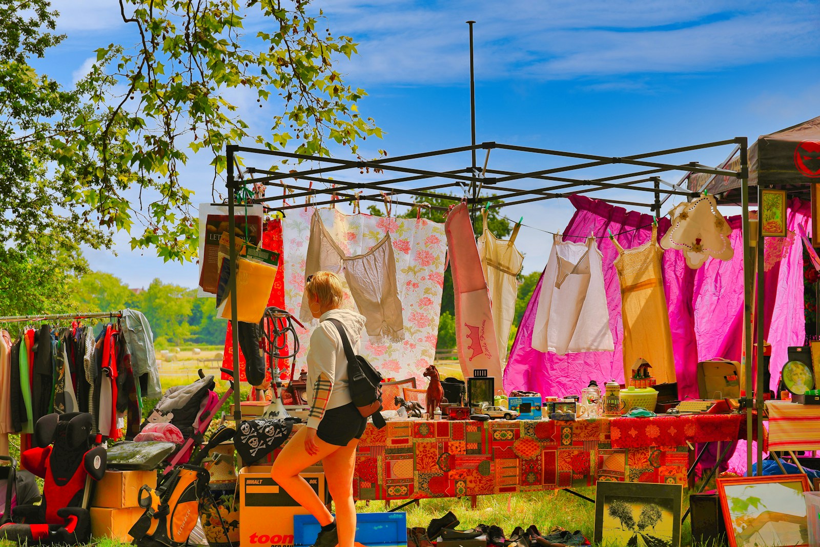 Woman browsing clothes at an outdoor market stall