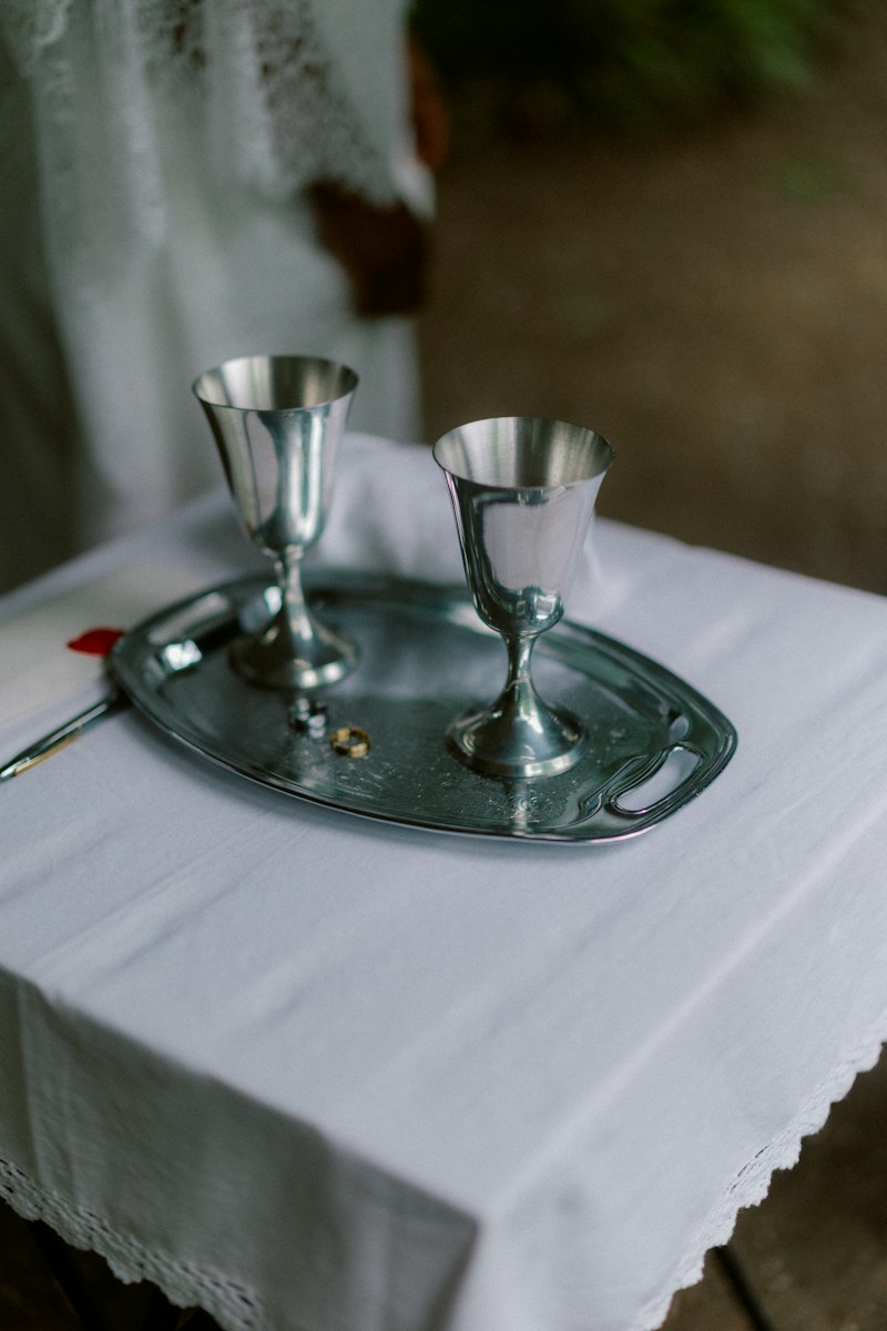 Two silver goblets and a ring on a metal tray