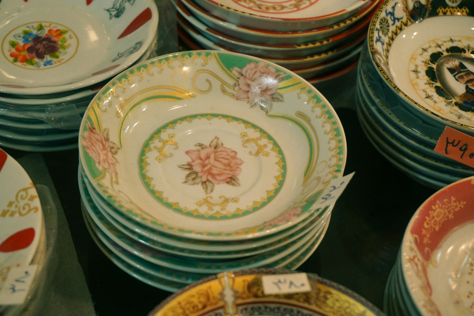 Stacks of ornate ceramic bowls and plates are displayed