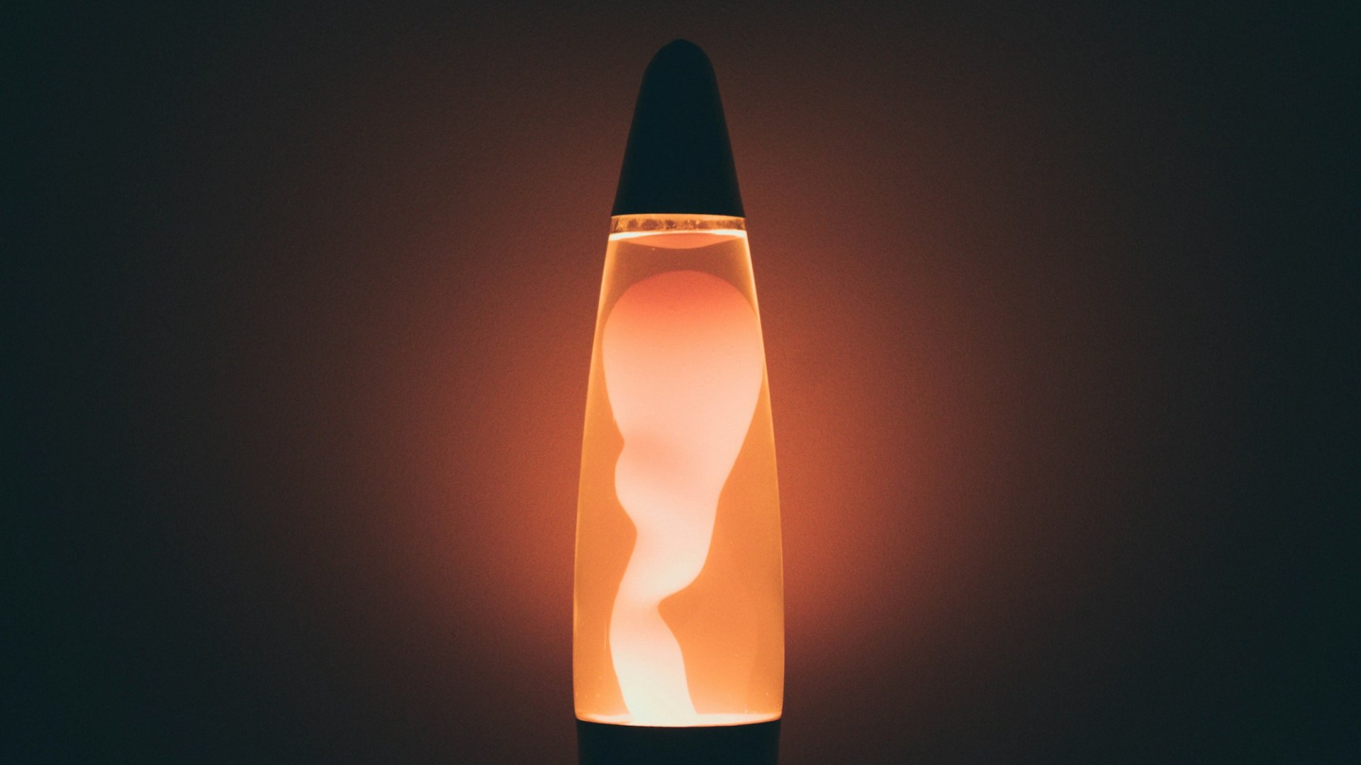 Glowing orange lava lamp on a dark background
