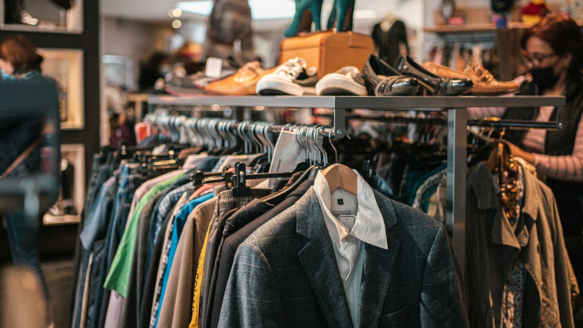 Rack of secondhand clothing and shoes in a vintage store