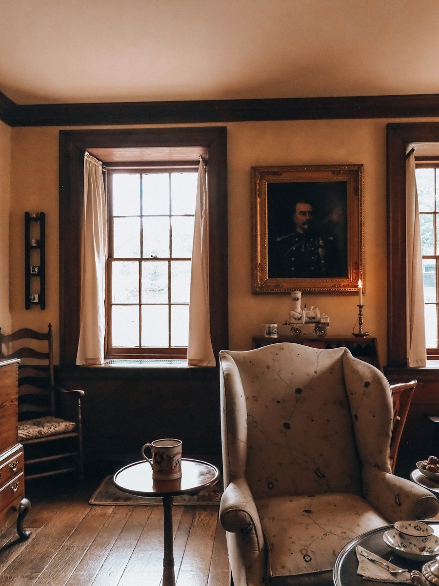Cozy vintage room with an armchair, windows, and portrait