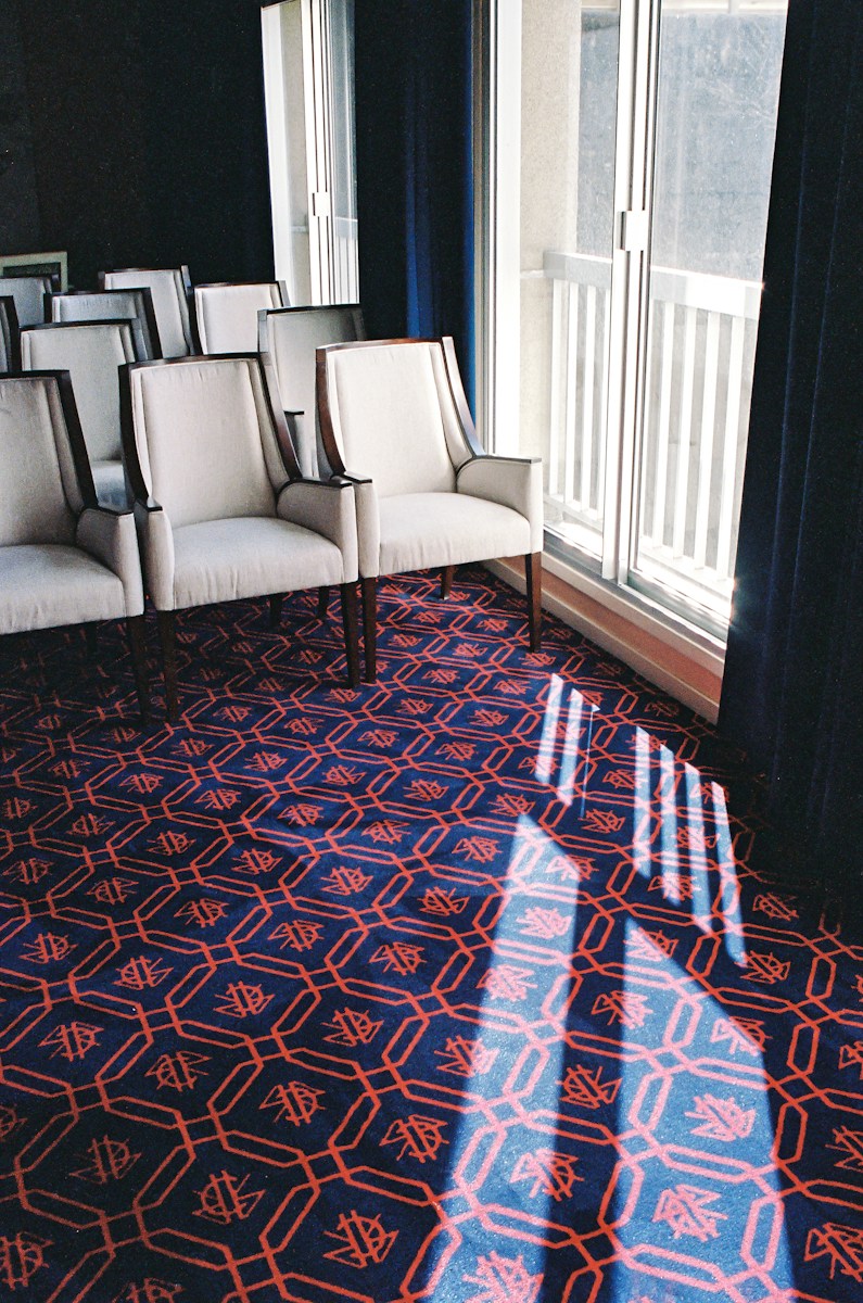 white leather sofa chair on red and blue area rug