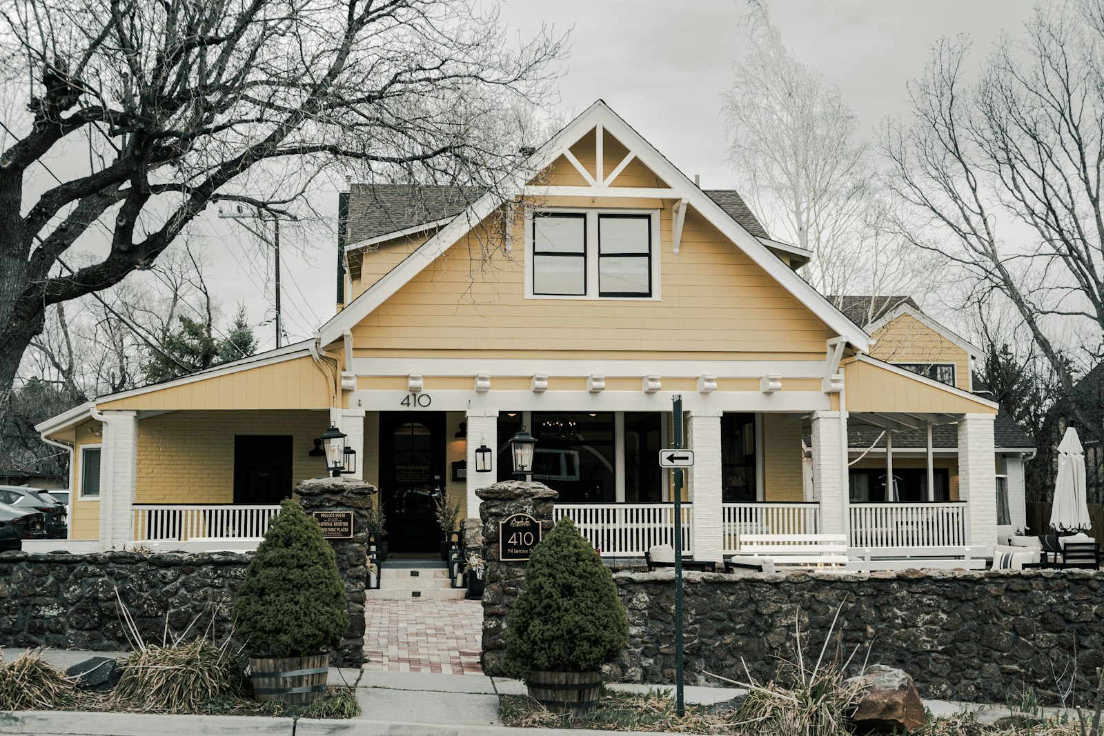 A charming yellow house with a large porch