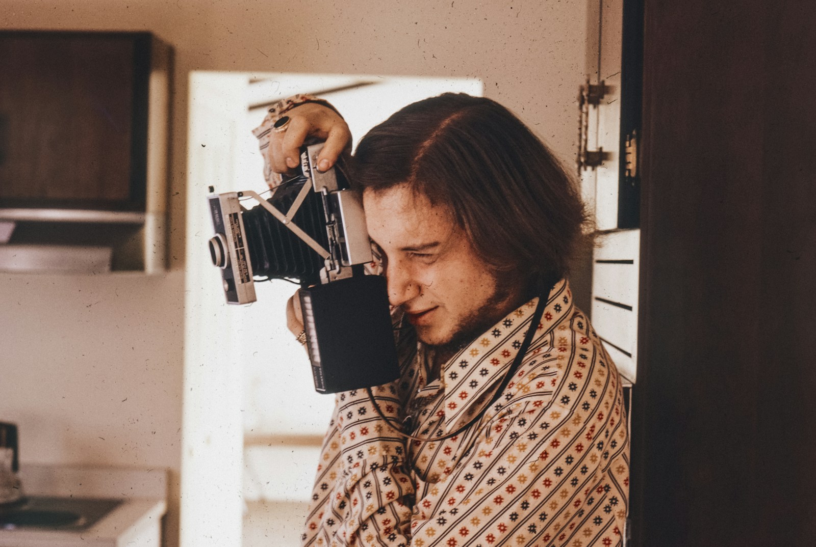 A man holding a camera up to his face