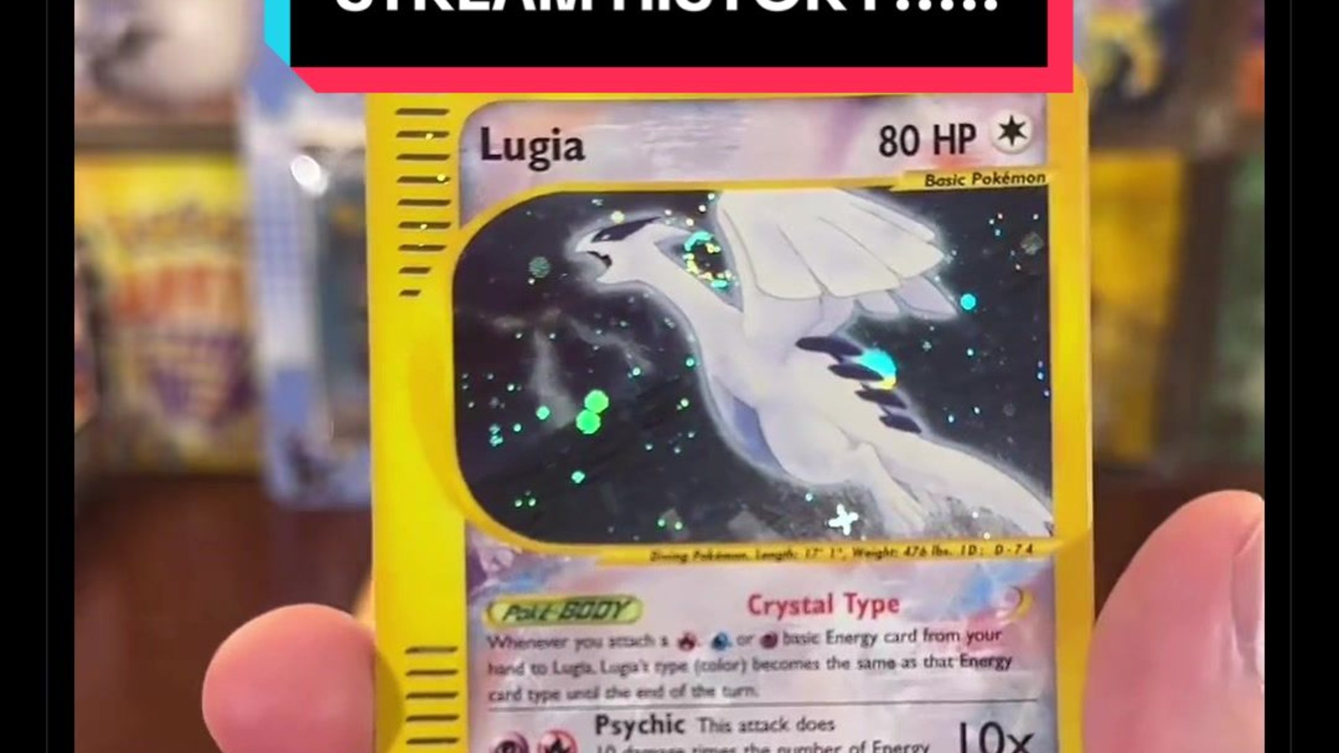 A collector holding up the Crystal Lugia card pulled live on camera from a vintage Pokemon booster pack