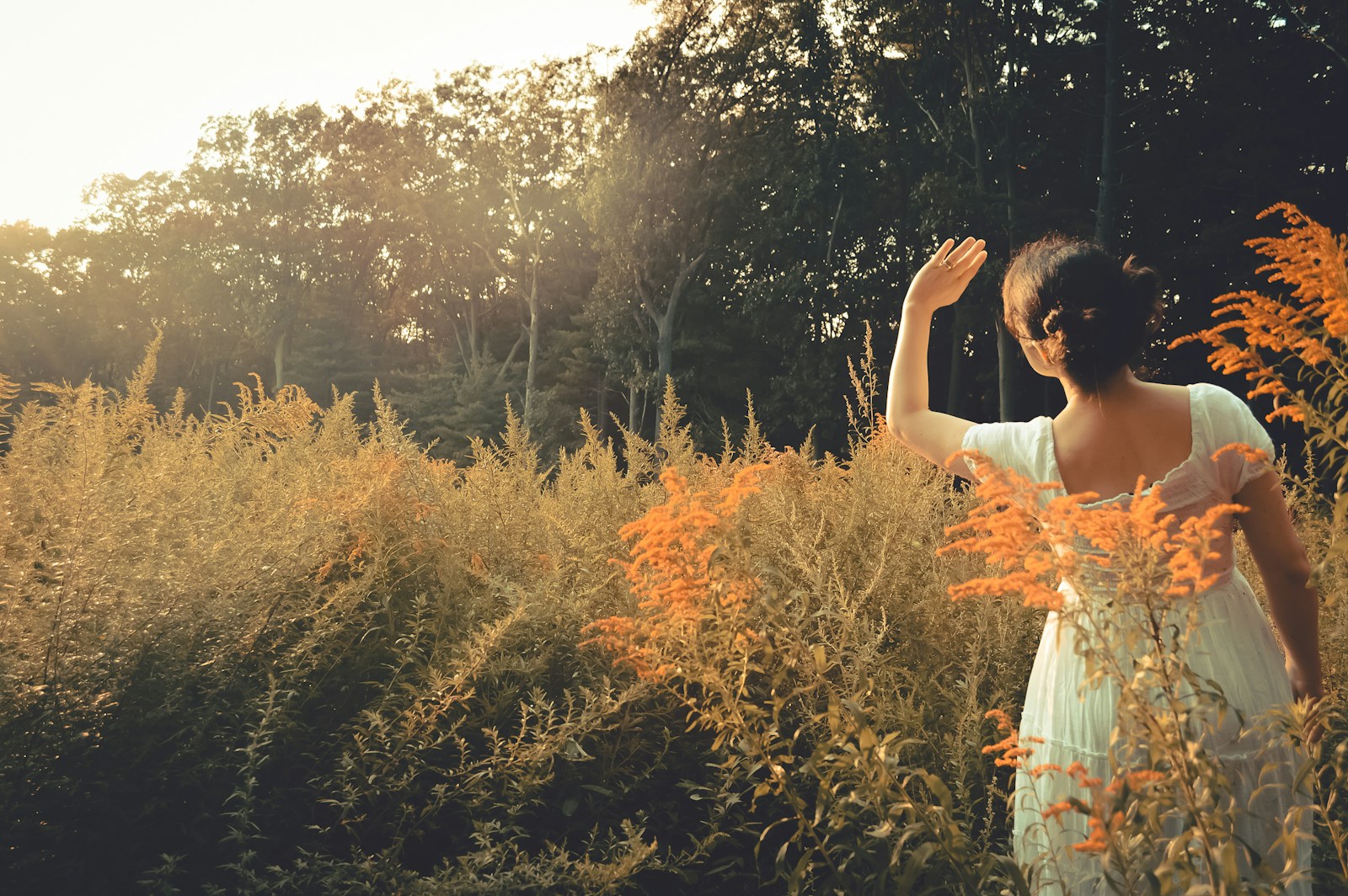 a woman standing in a field of tall grass