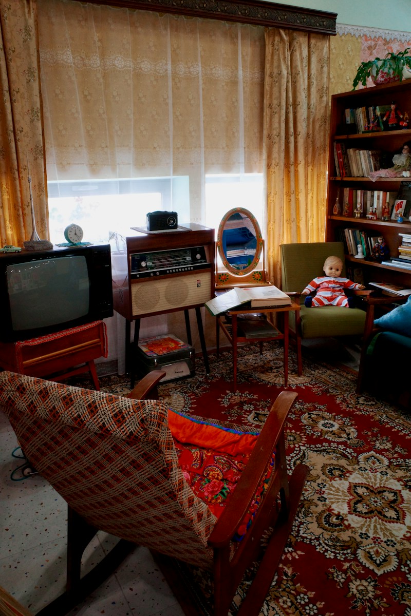 Vintage living room with old tv, radio, bookshelf, and doll