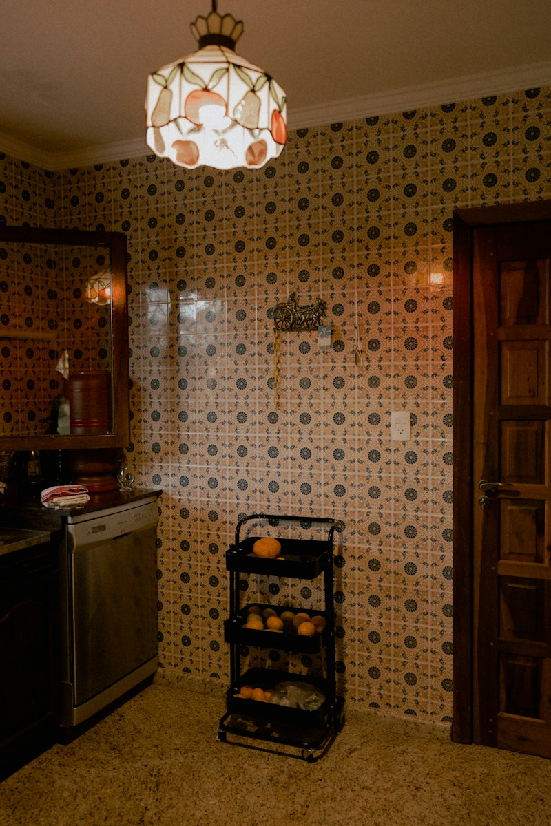 Dimly lit kitchen with patterned tiles and an orange rack