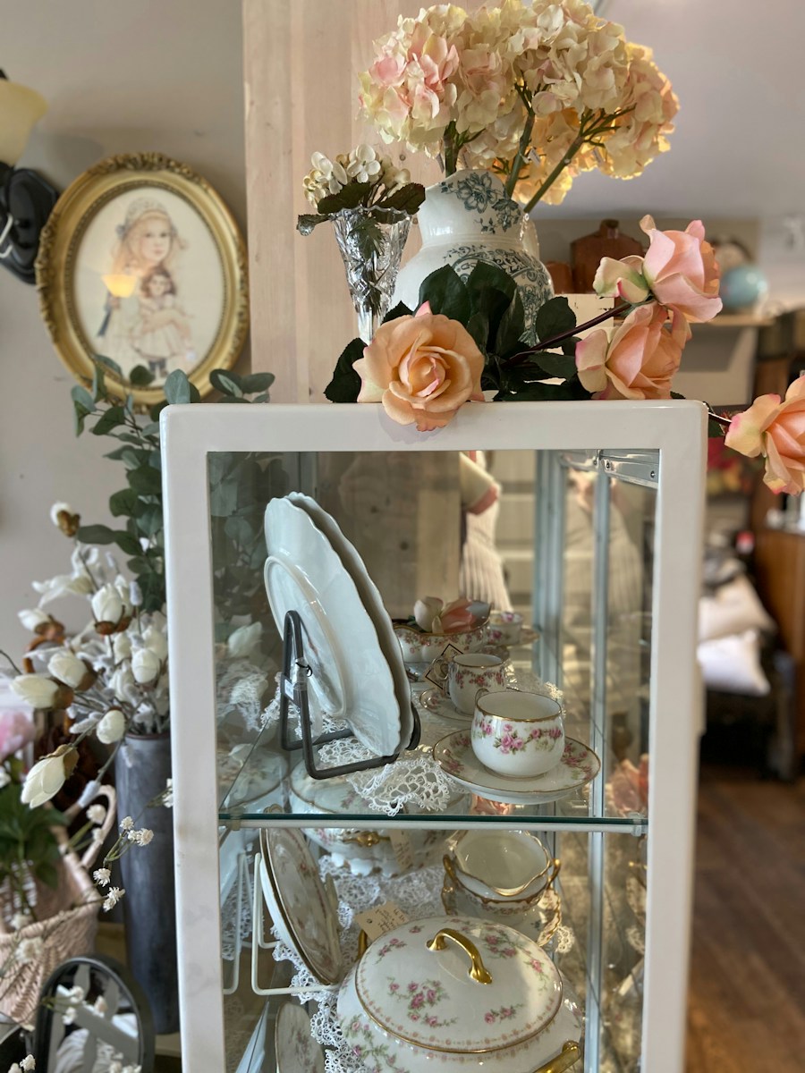 Decorative cabinet with antique china and flowers