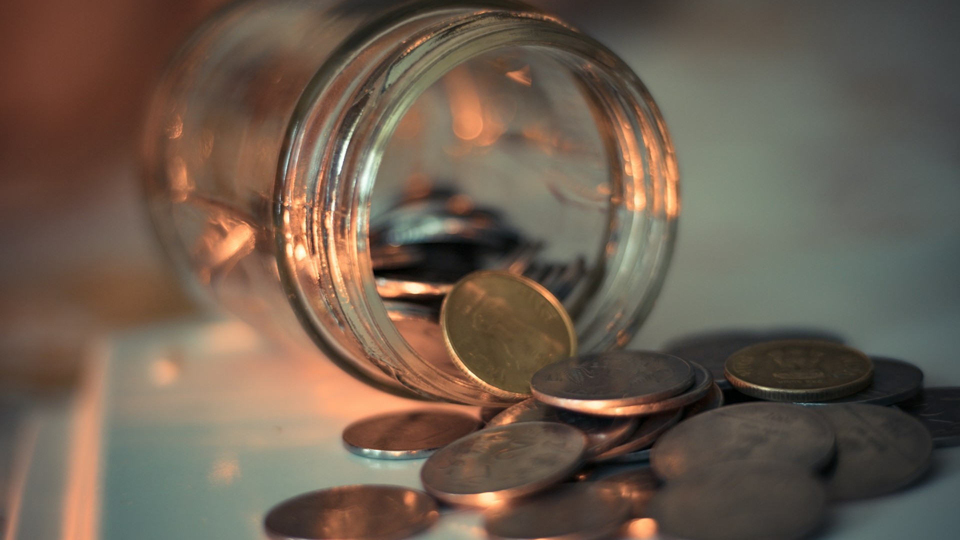 Unsplash photo by Napendra Singh showing a clear glass jar with coins in it