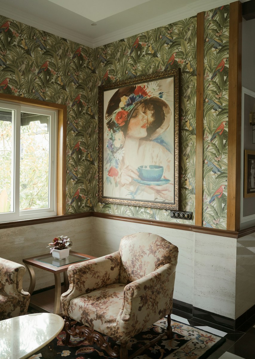 Cozy reading nook featuring vintage wallpaper and furniture