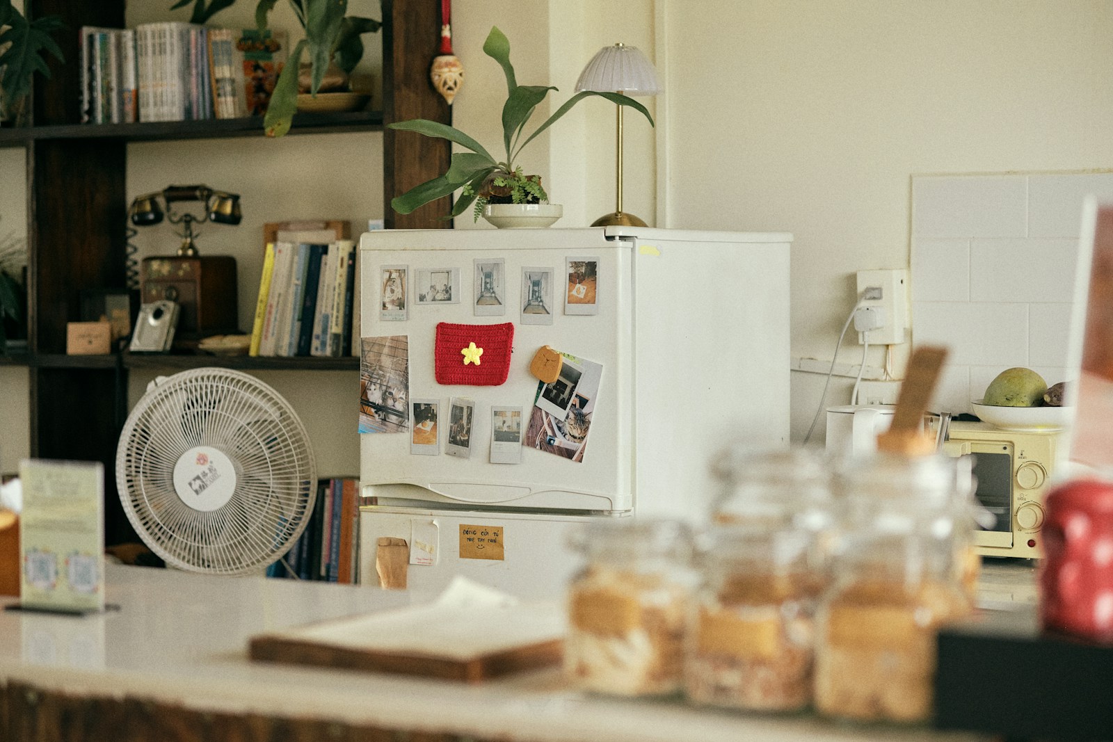 Refrigerator with flag magnet, fan, and jars on a counter
