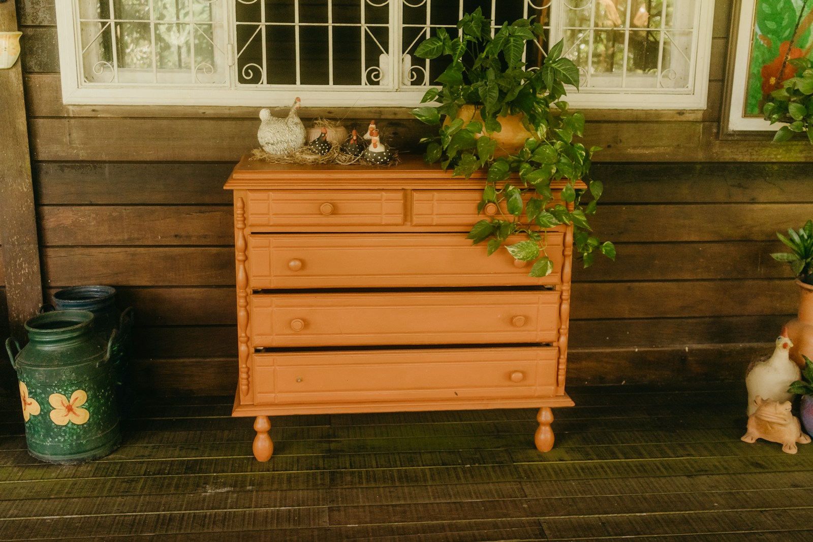 Wooden dresser with plant on rustic porch
