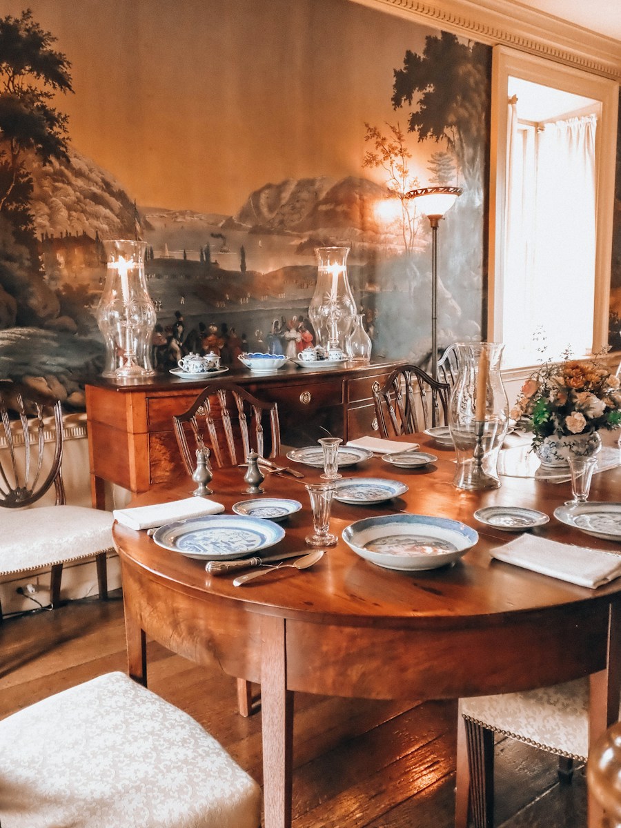 Elegant dining room with a set table and scenic mural