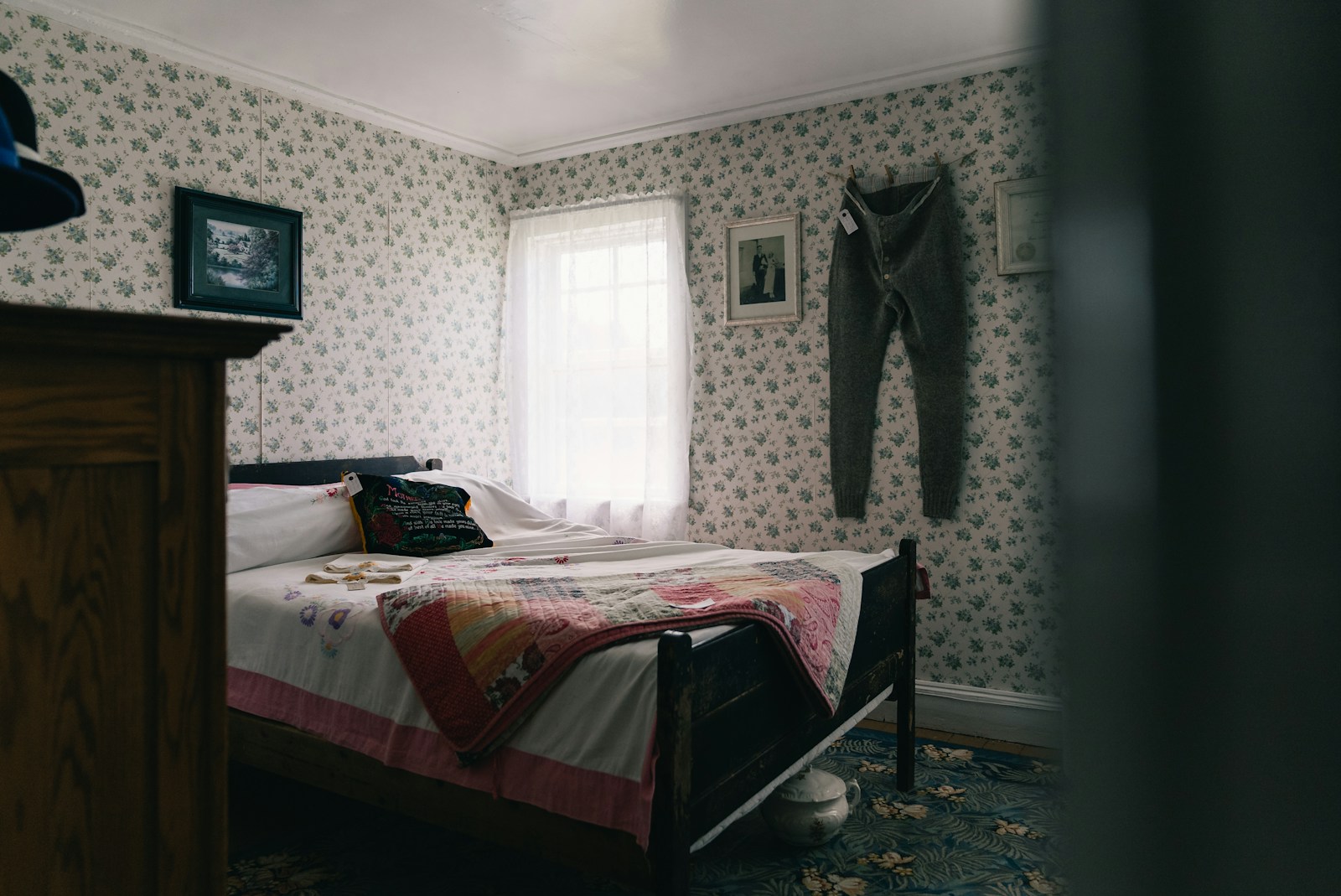 Cozy bedroom with floral wallpaper, bed, and bright window