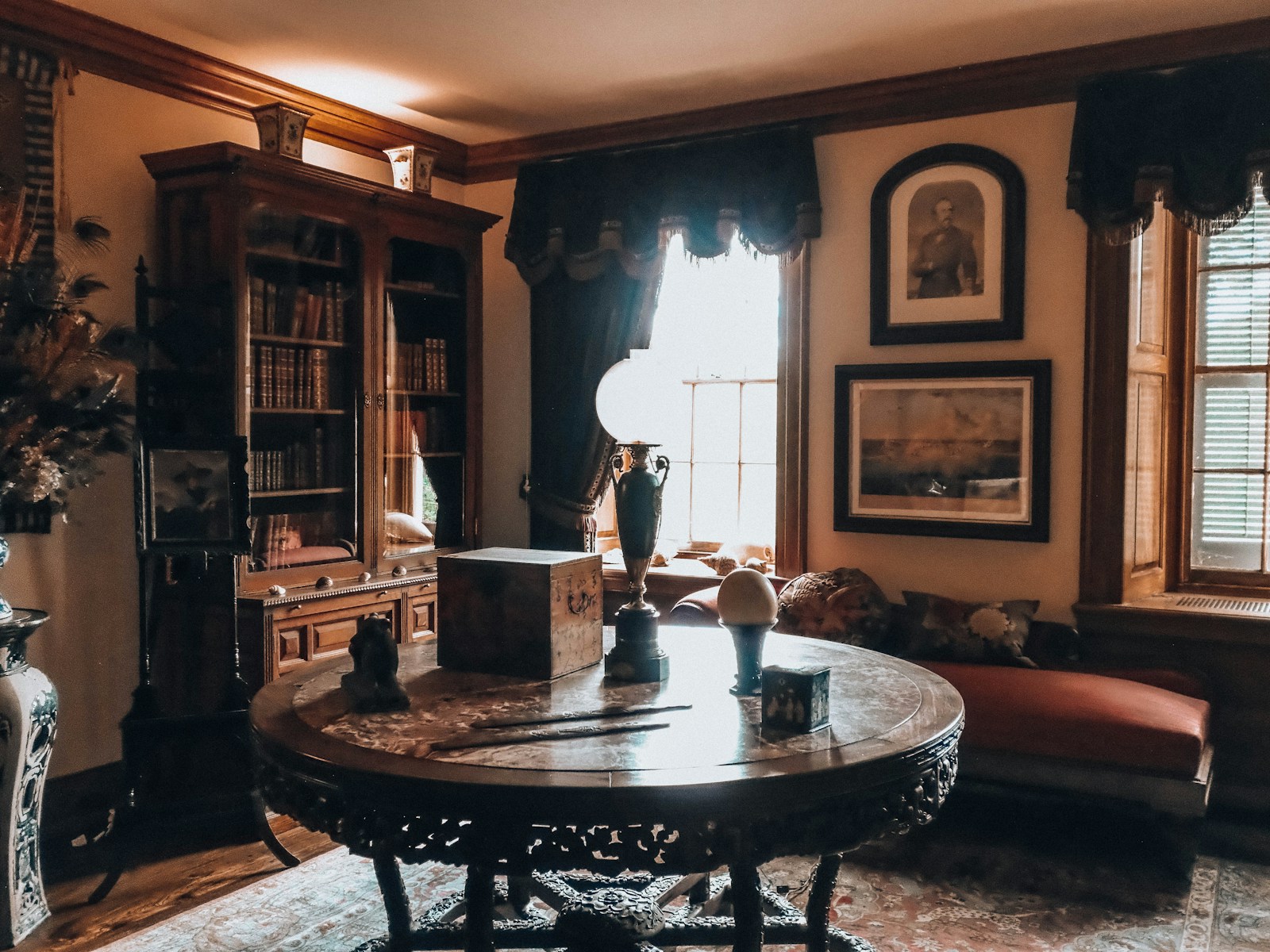Elegant antique room featuring a carved table and large bookshelf