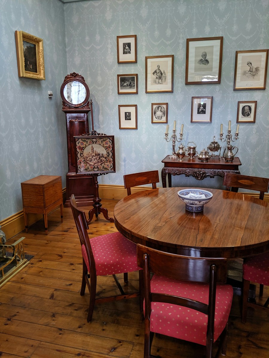 A dining room with antique furniture and framed art